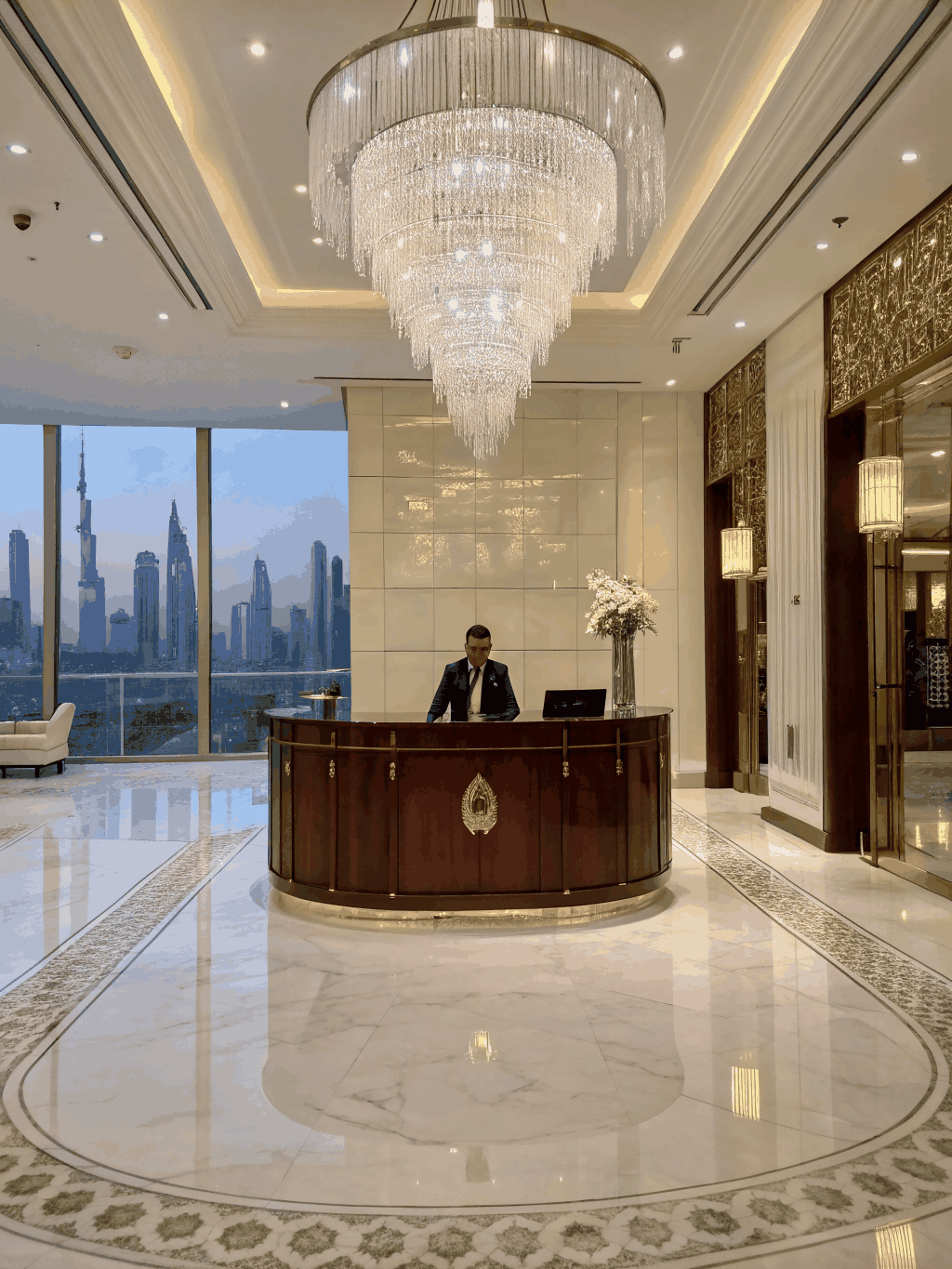 Grand 20-foot illuminated Christmas tree among marble columns in luxury Dubai hotel lobby